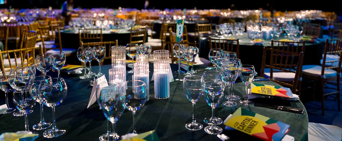 Elegant table setup at a Washington DC corporate gala with candles, glassware, and event materials