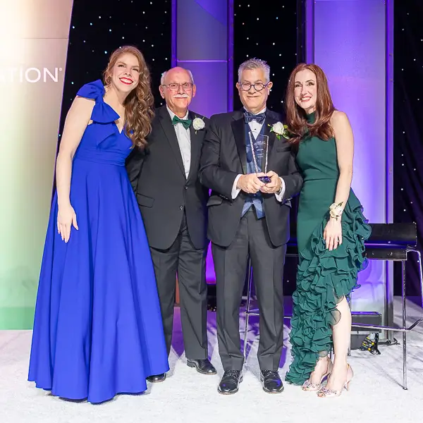 Award ceremony group photo on stage at a corporate gala event in Washington DC with honoree holding trophy