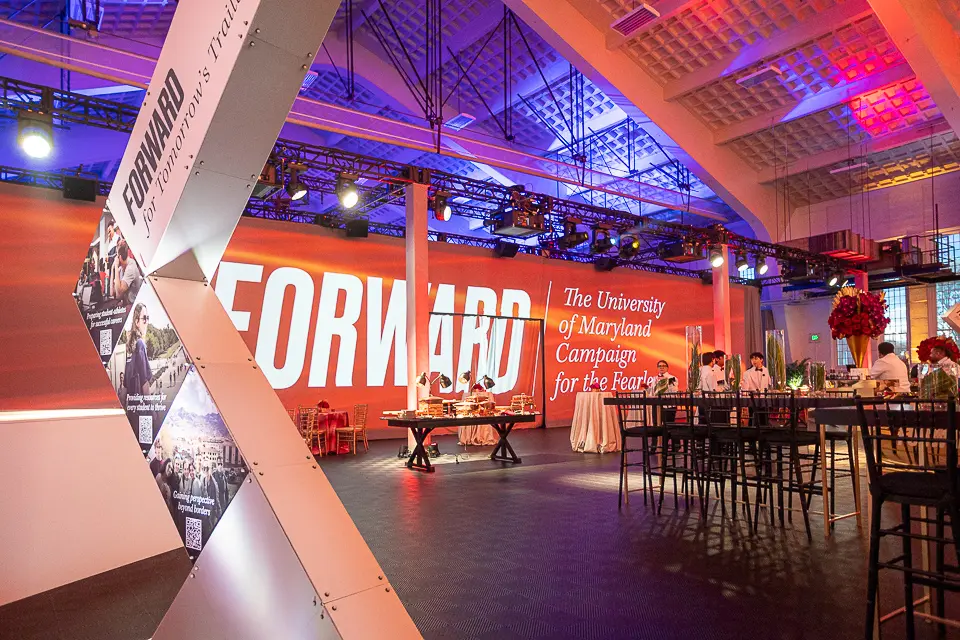 Forward campaign stage signage and sculptural display photographed before guests fill the reception space