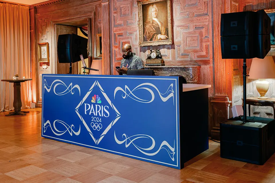 Blue Paris-themed DJ booth in a warmly lit reception room