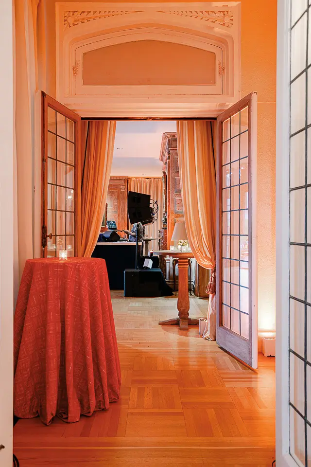 Tall cocktail table in an amber-lit hallway leading into the event