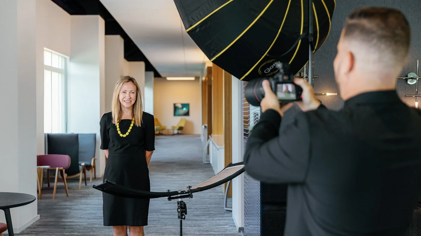 Corporate headshot session in a modern office hallway with professional lighting, photographed by District Pixel in Washington DC.