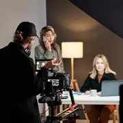 Corporate video production crew in Washington DC films a professional on-camera interview with cinema camera and studio lighting.