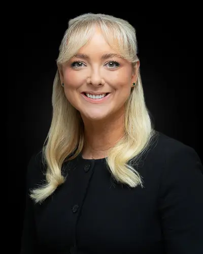 Professional corporate headshot of a blonde professional photographed against a black background in Washington DC by District Pixel