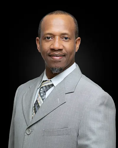 Professional corporate headshot of a male professional photographed against a black background in Washington DC by District Pixel